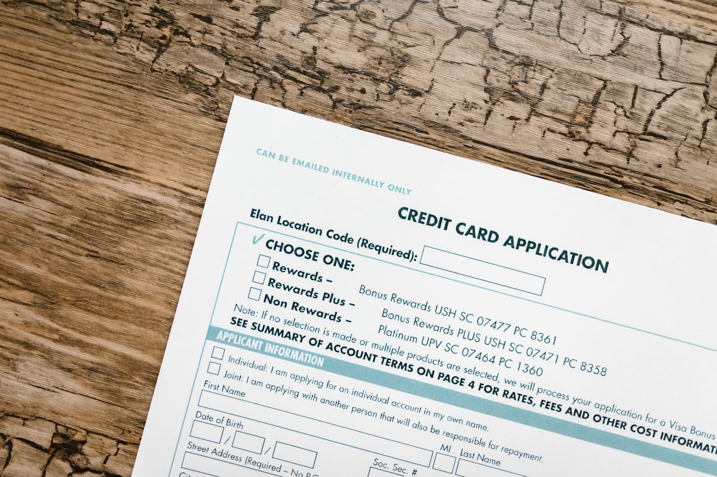 A credit card application form lying on a wooden desk