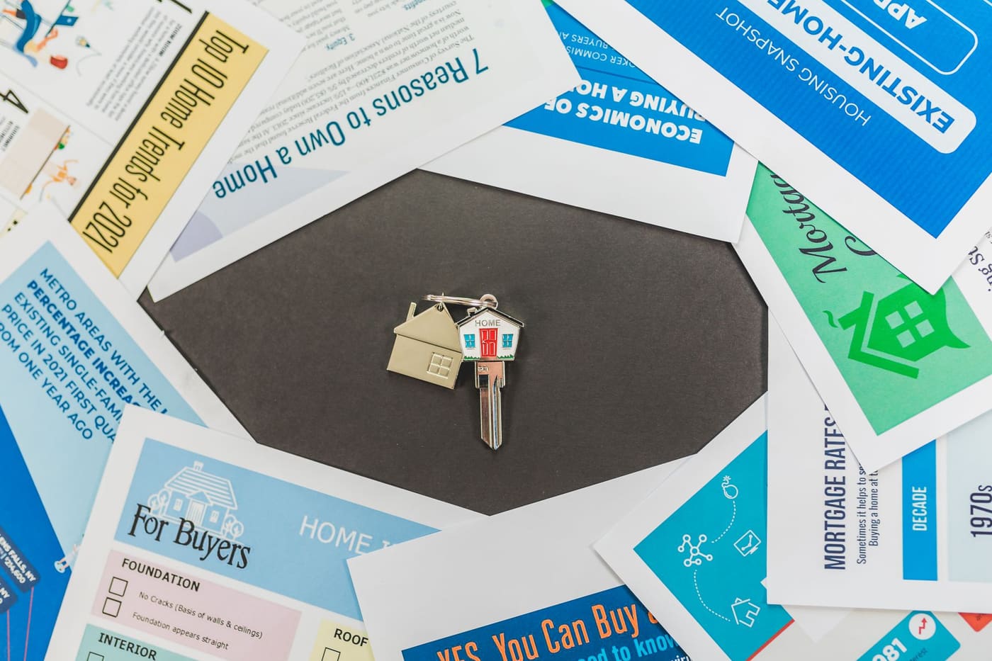 A house key on a spread of home buying brochures