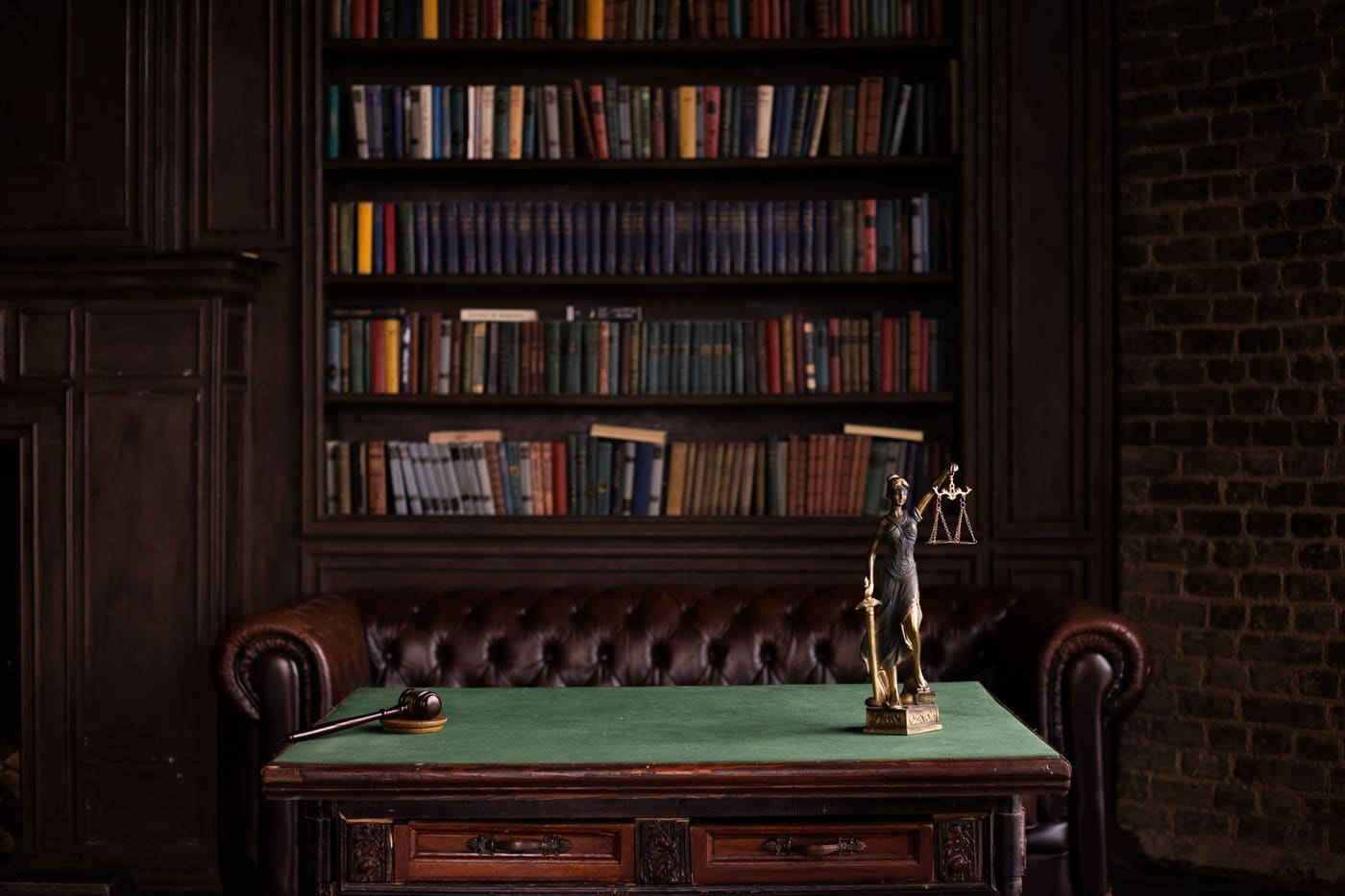 A study with shelves of law books and a small Lady Justice statue